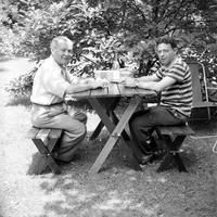 Two unidentified gentlemen at a picnic table
