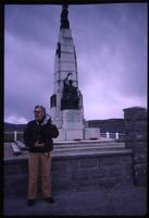 Jack Child standing next to World War I monument at Port Stanley