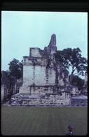 Lateral view of  Tikal structure with security guard in foreground 