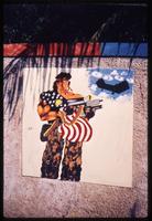 Graphic of solider carrying a machine gun draped with American flag