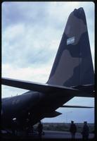 Rear view of Air Force C-130 plane and military personnel 