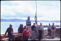 Locals and tourists near statue in village by Lake Titicaca