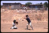 A batter and catcher wait for a pitch at a baseball game, Managua, Nicaragua