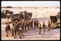 American soldiers standing between military transport vehicles during the Gulf War, Saudi Arabia
