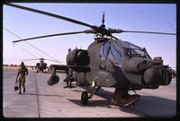 An American soldier walks next to an Apache helicopter during the Gulf War, Saudi Arabia