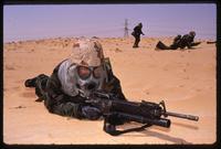 An American soldier lies in prone position in the desert during the Gulf War, Saudi Arabia