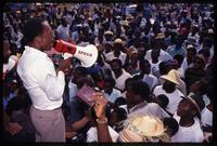 Presidential candidate Father Jean Bertrand Aristide speaking to a crowd on the campaign trail, Haiti