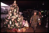 American soldiers from the 82nd Airborne Division gather in a room with a decorated Christmas tree, probably in Manuel Noriega's home, during the United States Invasion of Panama, Panama 
