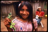 A Kuna girl holds a small iguana, Darien Gap, Panama