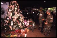 American soldiers with the 82nd Airborne Division look at a decorated Christmas tree in a home, probably Manuel Noriega's, during the United States Invasion of Panama, Panama City, Panama