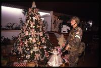 An American soldier with the 82nd Airborne Division looks at a decorated Christmas tree in a home, probably Manuel Noriega's, during the United States Invasion of Panama, Panama City, Panama