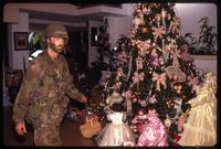 An American soldier with the 82nd Airborne Division walking past a decorated Christmas tree in a home, probably Manuel Noriega's, during the United States Invasion of Panama, Panama City, Panama
