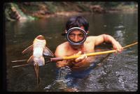 A man holds up a speared fish, Darien Gap, Panama