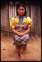 A Kuna woman poses while wearing traditional clothing and beaded jewelry, Darien Gap, Panama