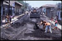Local citizens clean ash and debris from a street after the eruption of the Cerro Negro volcano