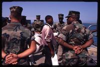 A Haitian refugee walking through rows of US Marines during his return to Haiti at the Guantanamo Bay Naval Base