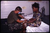 A young Haitian woman receives medical from US military personnel at the Guantanamo Bay Naval Base