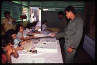 A poll worker handing the general election voting material to a man, Nicaragua