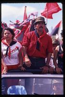 Daniel Ortega (wearing red) standing atop a jeep driving at a campaign stop for his re-election, Cuidad Dario, Nicaragua