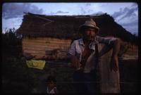A Miskito man and toddler outside a building in their village along the Coco River, Nicaragua