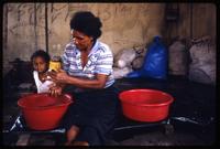 A Miskito woman sorting beans while a toddler sits next to her in their traditional homeland along the Coco River, Sáupuka, Nicaragua