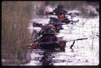 Alpha 66 volunteers wade through the water during a training exercise, Florida