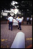 Four men take the casket of a dead cargo plane crew member into the American Embassy, Managua, Nicaragua