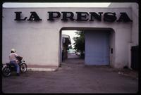A man sits on a motorcycle outside the entryway of opposition newspaper La Prensa, Managua, Nicaragua
