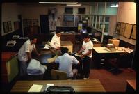 Four men gather around a desk in the newspaper of La Prensa, Managua, Nicaragua
