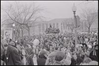 Alternate view of the crowd of students assembled to protest Nixon's inauguration and the Vietnam War filling the streets at Independence Ave and 6th St SW and the area around Seaton Section Park, 19 January 1969