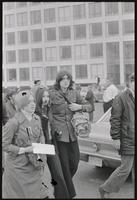 A young woman blows a whistle, flanked by fellow students near the Department of Transportation during a student protest of Nixon's inauguration and the Vietnam War, 19 January 1969