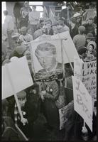 Protester holding a banner of Robert F. Kennedy at a rally to protest Nixon's inauguration and the Vietnam War, 19 January 1969