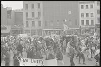 Demonstrators march past storefronts near Pennsylvania Ave NW and D St NW during a protest of Nixon's inauguration and the Vietnam War, 19 January 1969