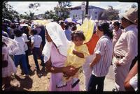A woman wearing a veil holds a child dressed as an angel while attending a Good Friday procession, Managua, Nicaragua