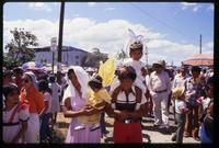 Children dressed as angels are carried through a crowd of people gathering at a Good Friday procession, Managua, Nicaragua