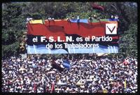 A crowd congregates beneath a billboard for the Sandinista National Liberation Front at a rally for the fifth anniversary of the Nicaraguan Revolution and Sandinista control of the government, Managua, Nicaragua
