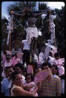 Children wearing angel wings sit at the base of a crucifix during a religious procession, Managua, Nicaragua