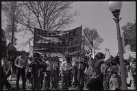 A crowd of protesters stand under banners ("Throw the Bum out: Organize to fight! Dayton, Ohio") at a rally to impeach Nixon, 29 May 1974