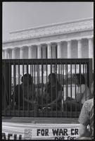 Young protesters sit in a mock prison cell draped in chains near the Lincoln Memorial to demonstrate against Nixon's war crimes during the Vietnam Veterans Against the War event, 04 July 1974