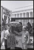 Figures representing Nixon and Kissinger pose in front of a trio of demonstrators in a mock prison cell in front of the Lincoln Memorial at a masquerade during the Vietnam Veterans Against the War demonstration, 04 July 1974