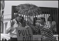 A figure of Nixon gives the thumbs up sign in front of a trio of demonstrators in a mock prison cell near the Lincoln Memorial at a masquerade during the Vietnam Veterans Against the War demonstration, 04 July 1974
