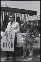 A figure of Nixon points exaggeratedly at a sign ("Pull out, Dick") next to a figure of Kissinger and a trio of demonstrators near the Lincoln Memorial at a masquerade during the Vietnam Veterans Against the War demonstration, 04 July 1974