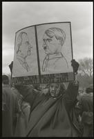 An alternate view of a protester against Richard Nixon's second inauguration holding a sign comparing Nixon to Hitler ("Nixon -- the anti Commy! Hitler -- the anti Jew!"), 20 January 1973