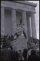 During a protest against Richard Nixon's second inauguration, a protester stands on one of the tripods flanking stairs leading up to the Lincoln Memorial, 20 January 1973