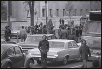 Alternate view of demonstrators in the May Day protests march with flags in the middle of oncoming traffic on Pennsylvania Avenue, near the Federal Trade Commission building, 03 May 1971