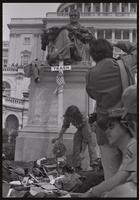 Alternate view of a Vietnam veteran adding his hat to the  pile of military decorations discarded at the base of the John Marshall statue on the US Capitol grounds during veteran demonstrations before Vietnam War Out Now, 23 April 1971