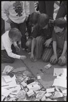 Alternate view of children picking up and examining military decorations discarded at the base of the John Marshall statue at the US Capitol during veteran demonstrations before Vietnam War Out Now, 23 April 1971