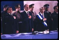President Alfredo Cristiani, former President José Napoleón Duarte, and Vice President José Francisco Merino López standing for the national anthem at the inauguration ceremony, San Salvador, El Salvador