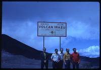 Jack Child and tourists standing beneath Irazú volcano welcome sign