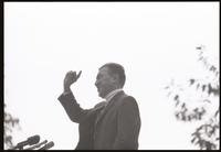 Close-up of former U.S. Representative Adam Clayton Powell pointing to the sky as he speaks to a crowd at American University, 13 October 1968